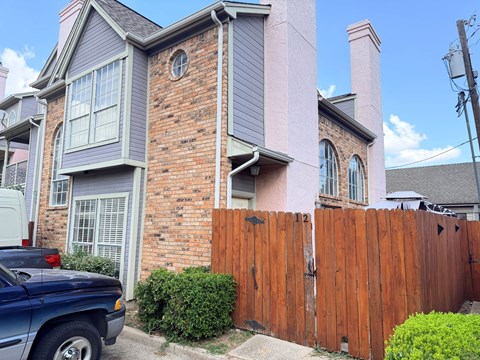 A blue truck is parked in front of a house.